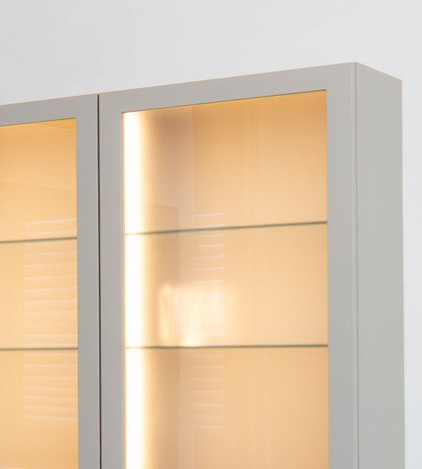 Two lit display cabinets with glass shelves set into a painted wall