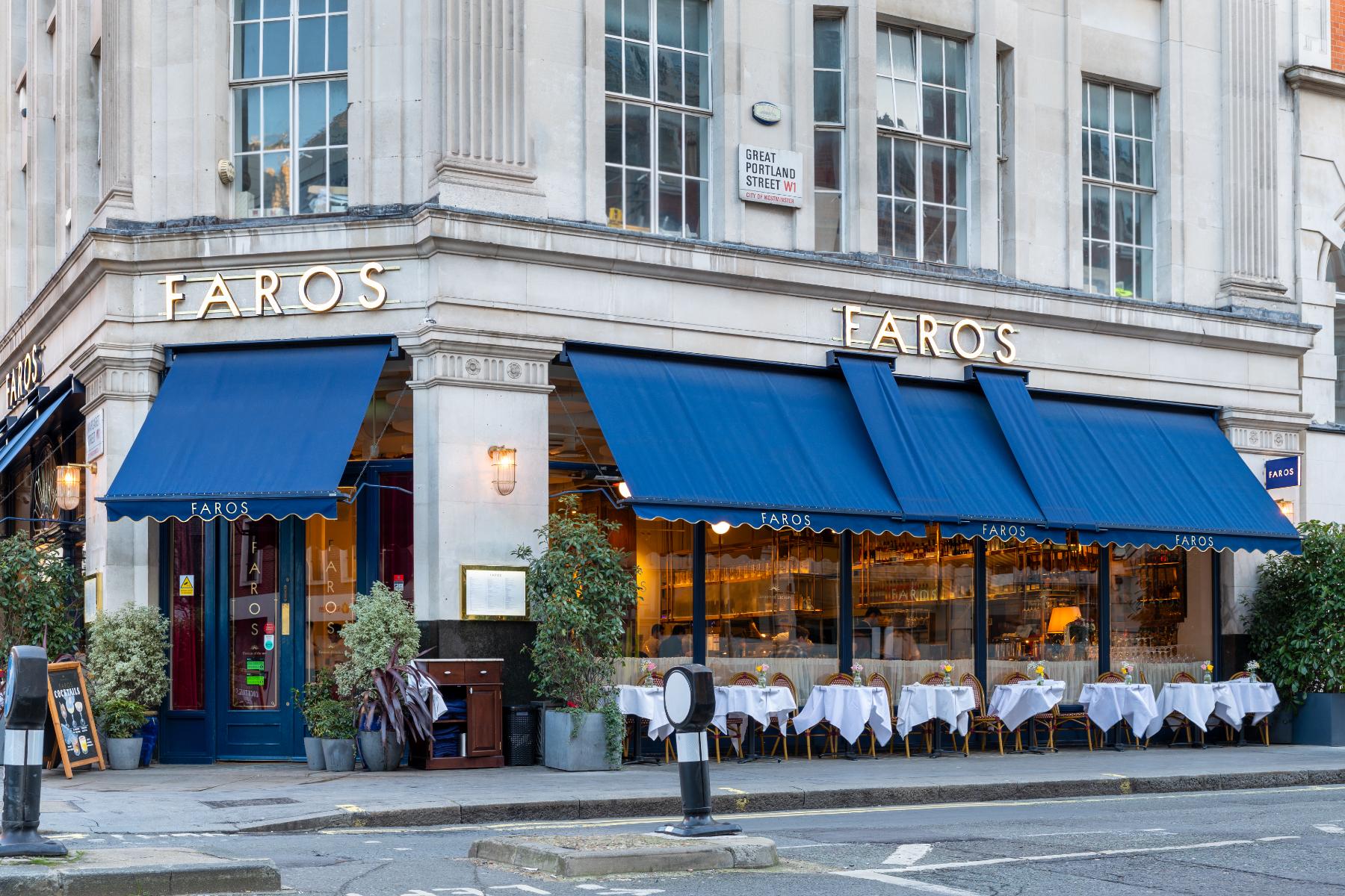 Faros restaurant corner shopfront with timber frame, glazing, gilded lettering and blue awnings