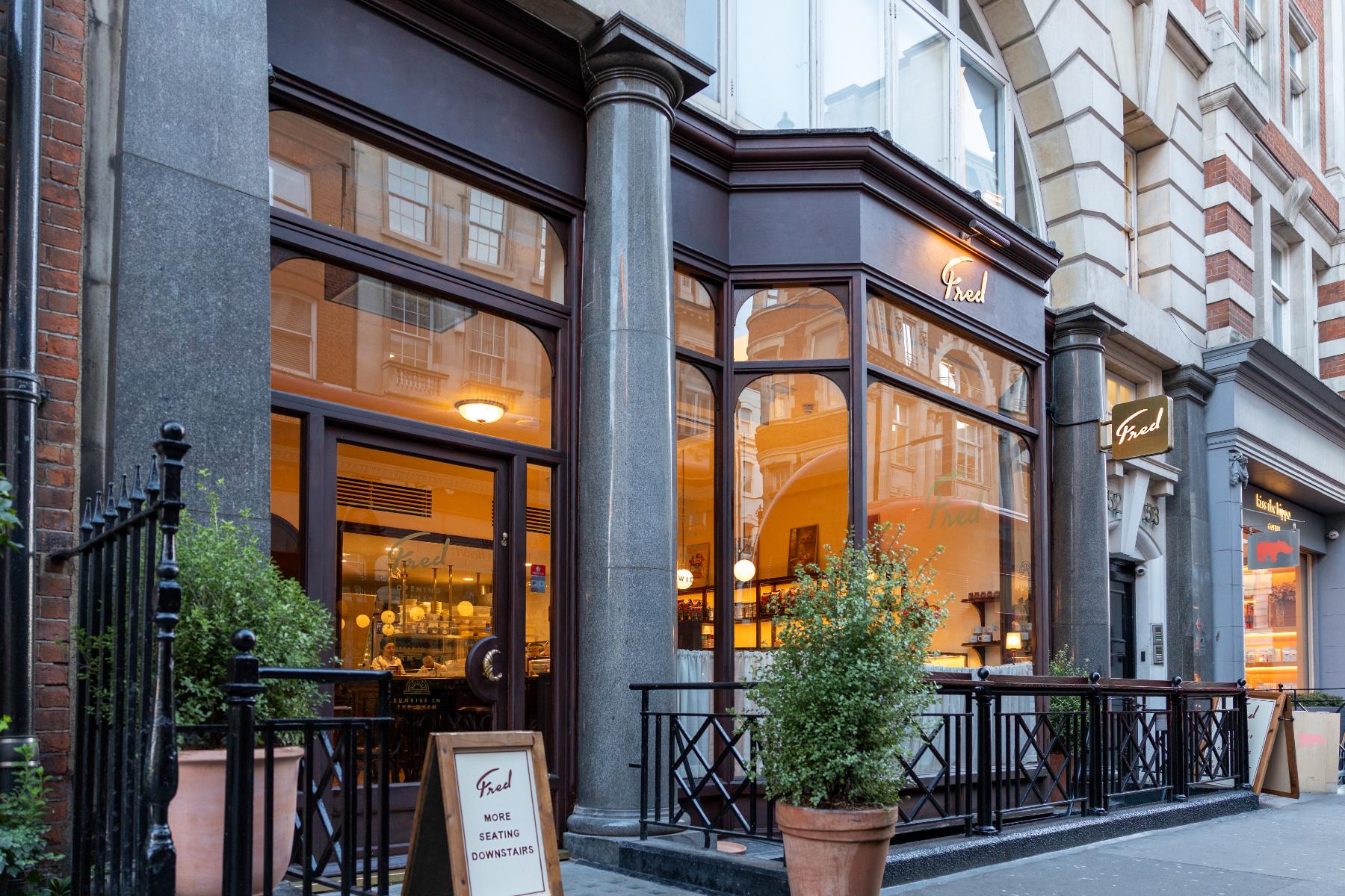 Fred shopfront with dark timber frame, arched glazing and gilded lettering